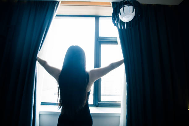 istock young woman open the curtains 851479038