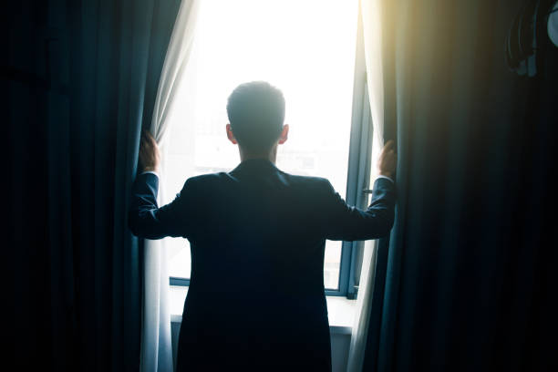 istock Businessman open curtains in the morning 851479108