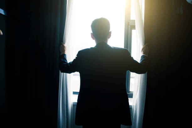 istock Businessman open curtains in the morning 851479182