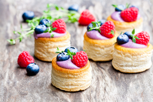 puff  pastry stuffed with soft blueberry curd with berries and thyme on rustic wooden background