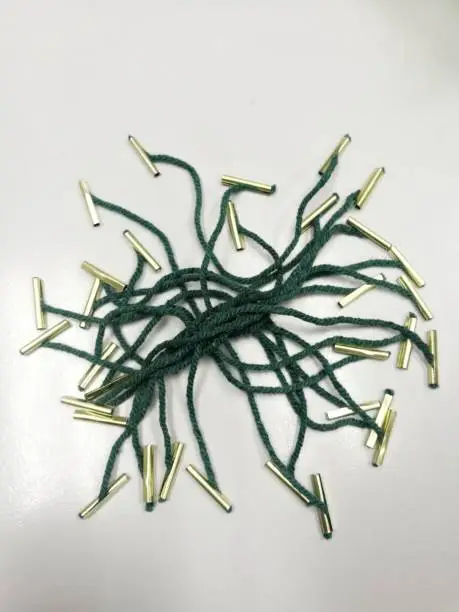 Green string with metal ends to tie files together