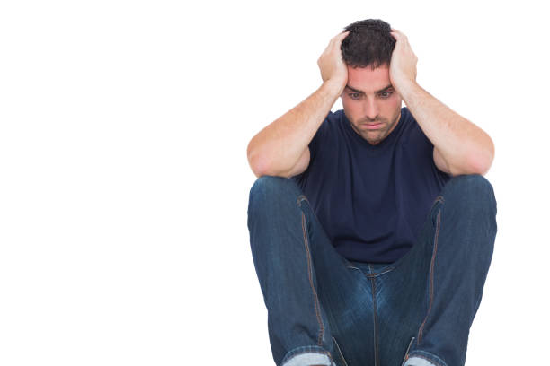 istock Sad man sitting on the floor while holding his head 851497766