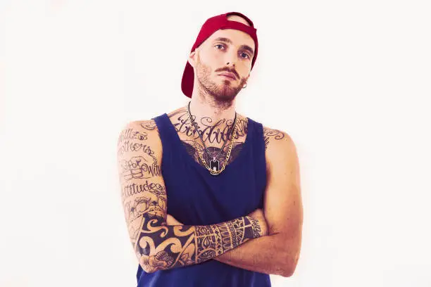 tattooed rap singer posing in studio on a white background