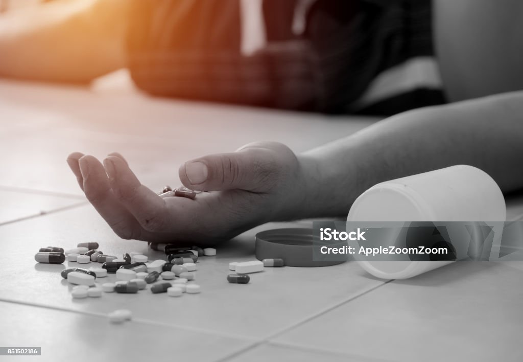 Overdose - close up of pills and addict lying on the floor Opioid Stock Photo