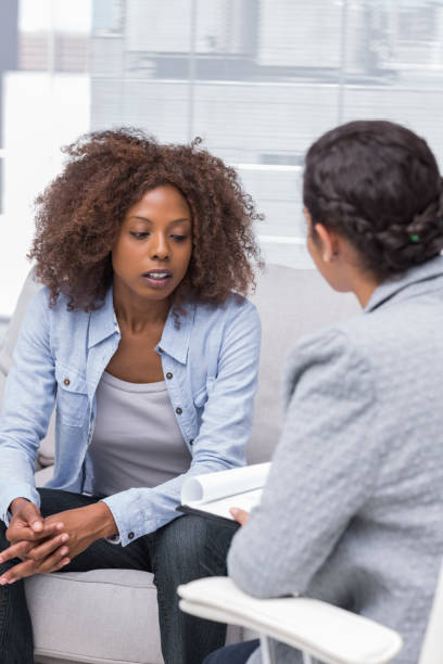 istock Patient sitting on sofa and talking to therapist 851505236