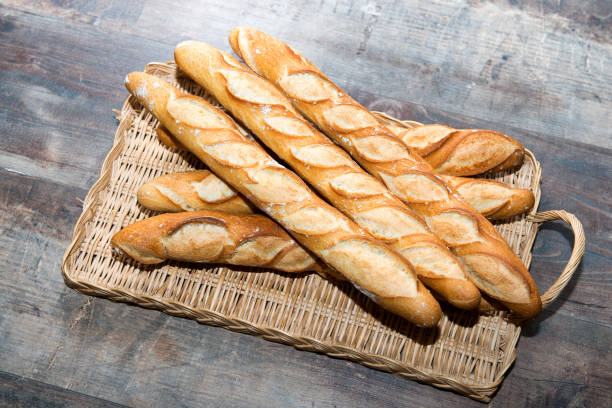 palo de pan francés sobre una mesa rústica - market european culture europe food fotografías e imágenes de stock
