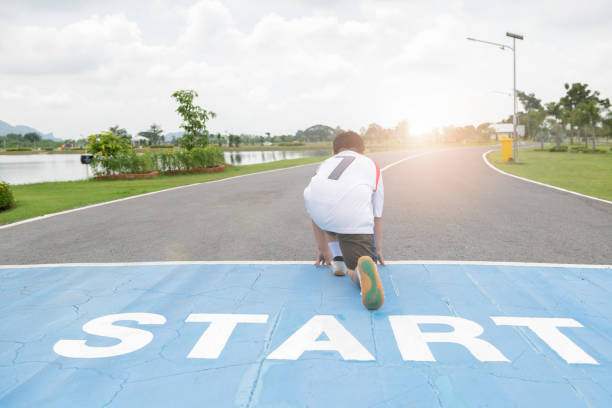 開始位置の実行の準備ができてのファットボーイの裏面。 - starting line competition running jogging ストックフォトと画像