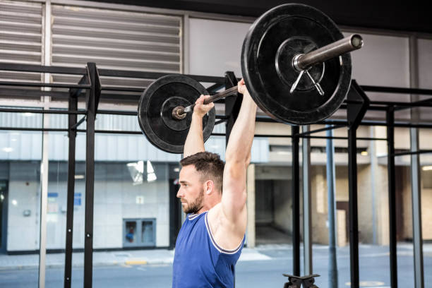 istock Muscular man lifting barbell 851516660