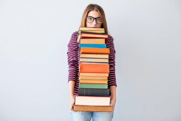 istock Student woman holding pile books 851544314