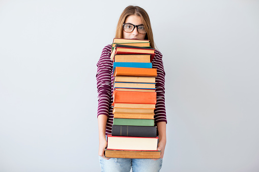 Student woman holding pile books