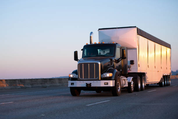 istock Dark big rig semi truck with bulk trailer running highway in sunset light 851548268