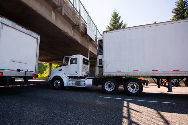istock Day cab big rig semi truck going with reefer trailer with refrigeration unit under the bridge on roadside with traffic 851548768