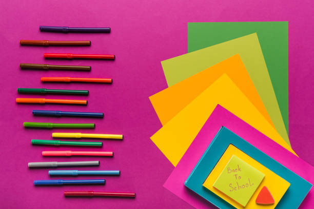 composition of colorful papers and markers in row on purple