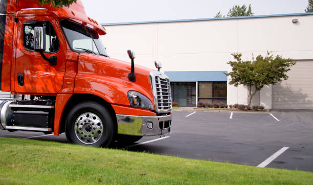 istock Orange rig middle class semi truck tractor on warehouse parking lot 851552120