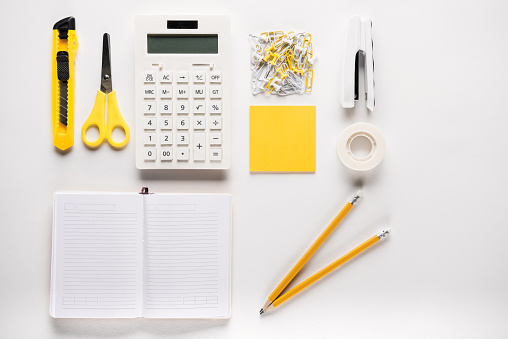composition of white school supplies with opened blank notebook