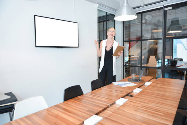 istock Business blonde woman presenting a project on blank screen TV 851555936