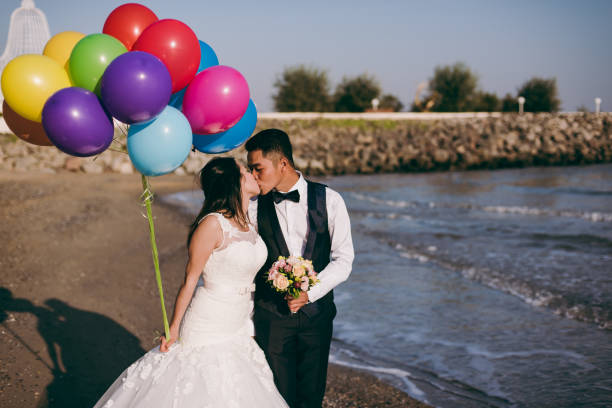 istock Wedding couple with balls walking along the seashore 851559952