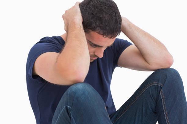 istock Unhappy man with head in hands sitting on floor 851564964