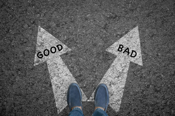istock man standing on road with direction arrow choices Good and Bad or move forward. concept solution and start. 851565178