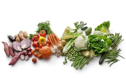 Food cooking ingredients background with fresh vegetables, herbs, beans, spices and olive oil on white stone table top view. Healthy vegetarian eating