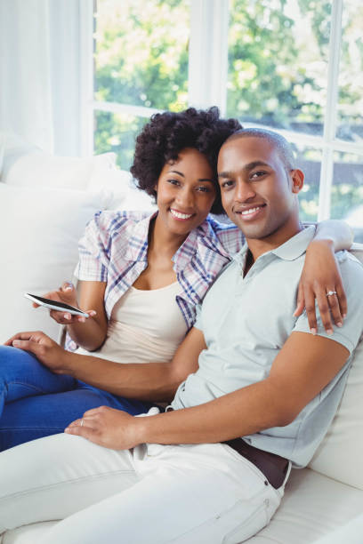 istock Happy couple using smartphone on the sofa 851575078