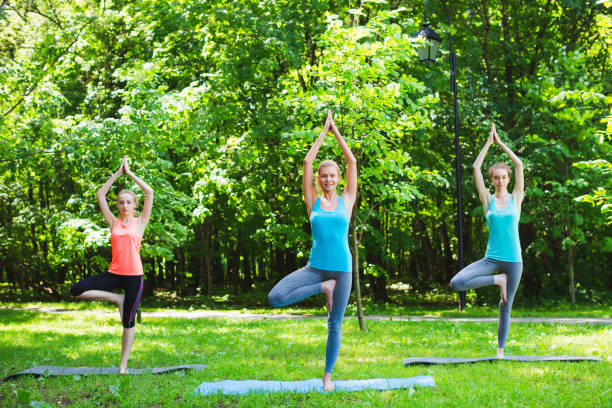 istock Fitness group doing yoga in park on a sunny day 851575770