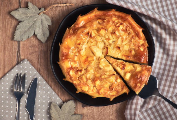 istock Homemade round apple pie with a slice cut out on a black dish, top view 851578614