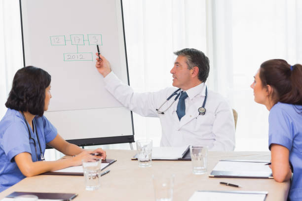 istock Doctor pointing to board during meeting 851585134