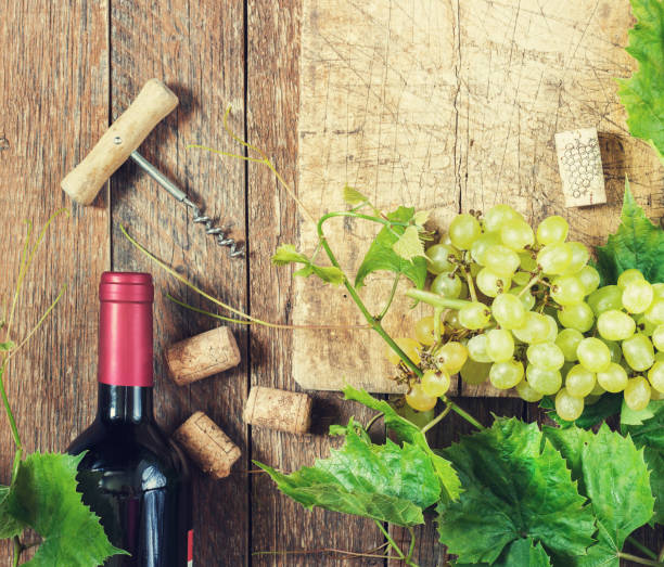 istock Grapes,a bottle of wine, corks and corkscrew on a wooden old table, rustic style 851586288
