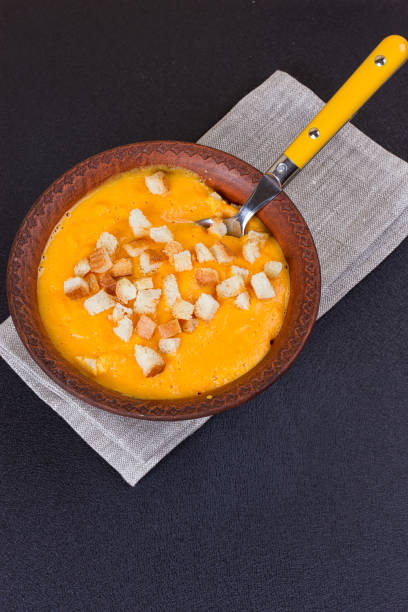 istock Pumpkin and carrot soup with cream and parsley 851590610