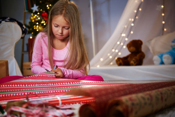 istock Cute girl cutting a Wrapping paper 851593640