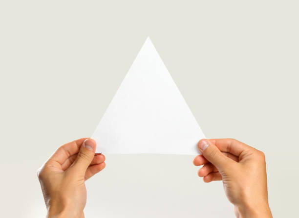 istock Male hands holding a white triangular piece of paper. Isolated on gray background. Closeup 851613002