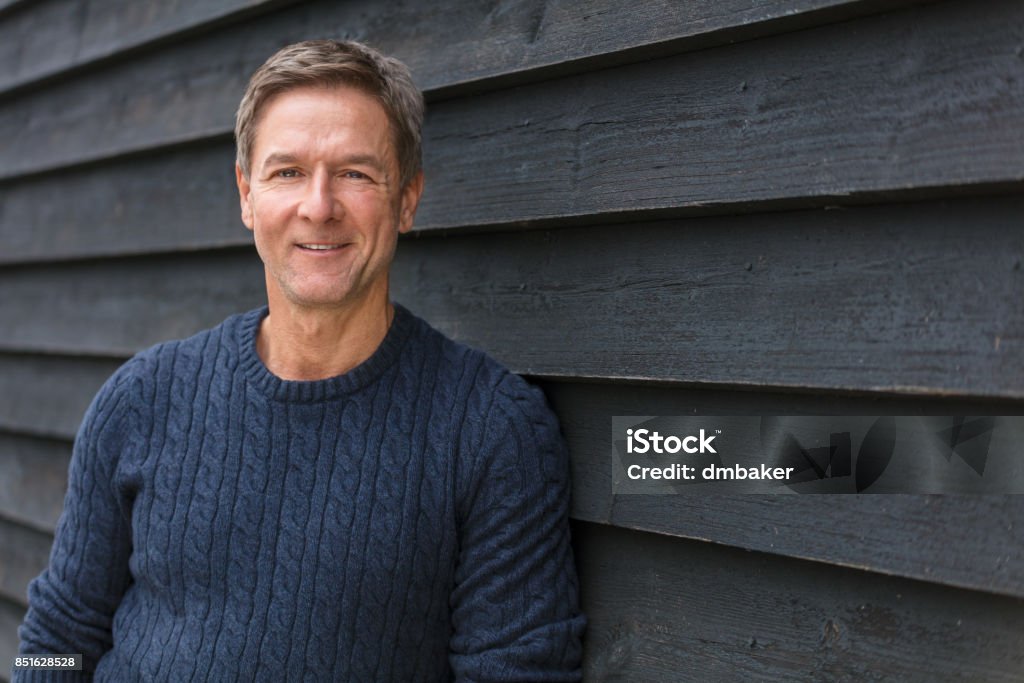 Attractive, successful and happy smiling middle aged man male outside wearing a blue sweater Portrait shot of an attractive, successful and happy smiling middle aged man male outside wearing a blue sweater Men Stock Photo
