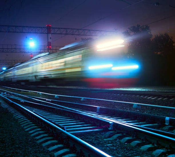 istock train rushes on rails at night 851633328