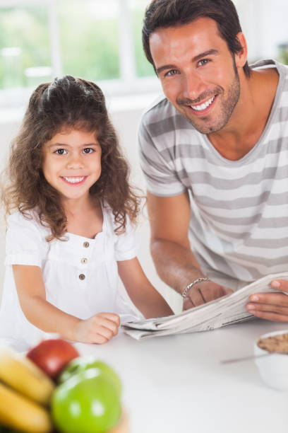 istock Dad and daughter reading a newspaper during breakfast 851666220