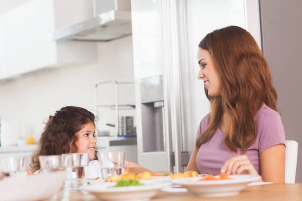 istock Smiling girl and her mother at the dinner table 851675000