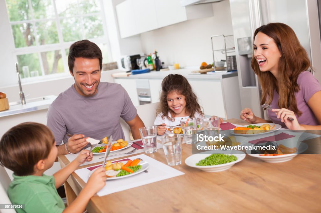 Famille de rire autour d’un bon repas - Photo de Famille libre de droits