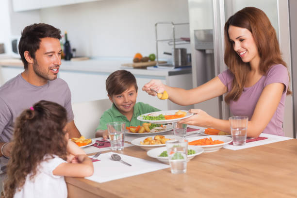istock Mother serving vegetables to daughter at dinner 851675576