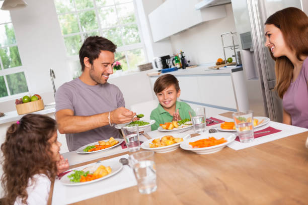 istock Father serving vegetables to son 851675624