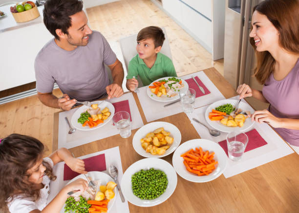istock Family smiling around a healthy meal 851675644