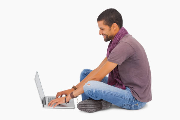 istock Man wearing scarf sitting on floor using laptop 851679908