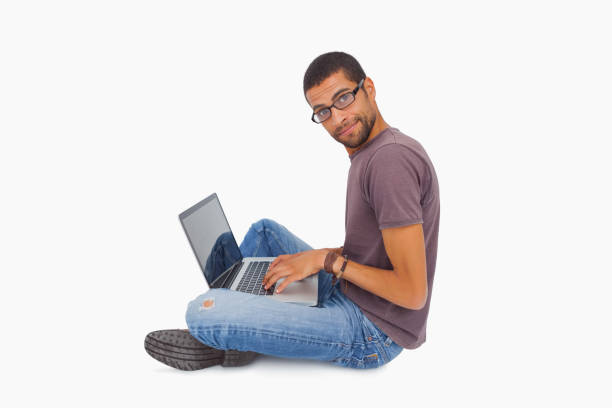 istock Man wearing glasses sitting on floor using laptop and looking at camera 851680142