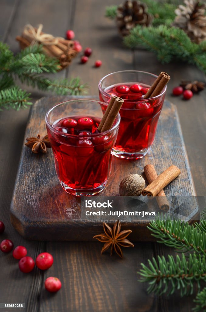 Cranberry drink on wooden background decorated with fir branches and fresh berries Cranberry drink on wooden background decorated with fir branches and fresh berries, selective focus Advent Stock Photo
