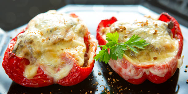 istock Stuffed Red bell peppers with mushrooms on the black plate 851695418