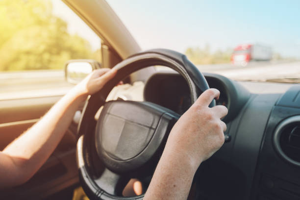 istock Female hands holding on black steering wheel 851695962
