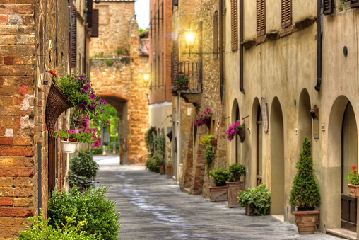 Flowery streets on a spring day in a small old village Pienza, Tuscany.