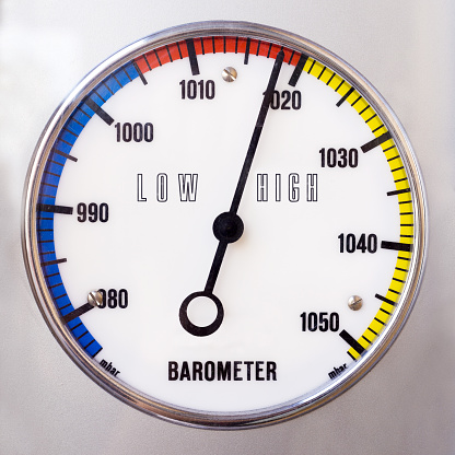 Round analog barometer with scale and words low, high