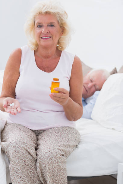 istock Old woman with an opened pill bottle 851703176