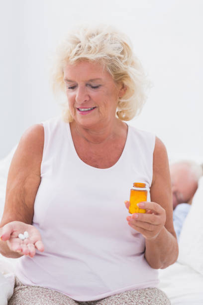 istock Smiling aged woman with the opened pill bottle 851704416
