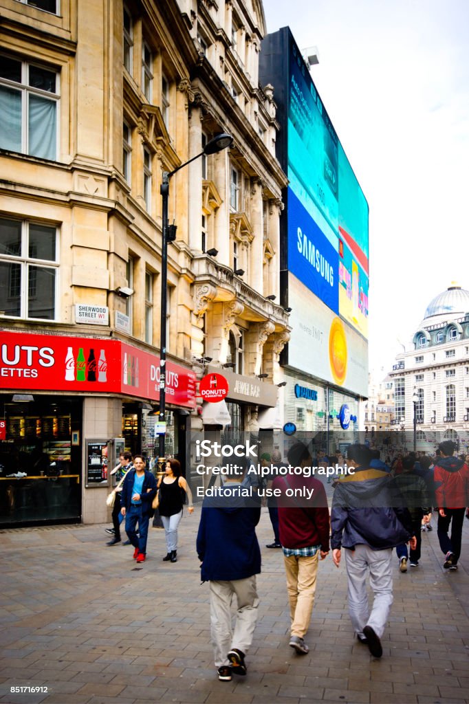 Tourists near Piccadilly Circus Groups of tourists in Piccadilly Circus with large neon signs in the background. Active Lifestyle Stock Photo